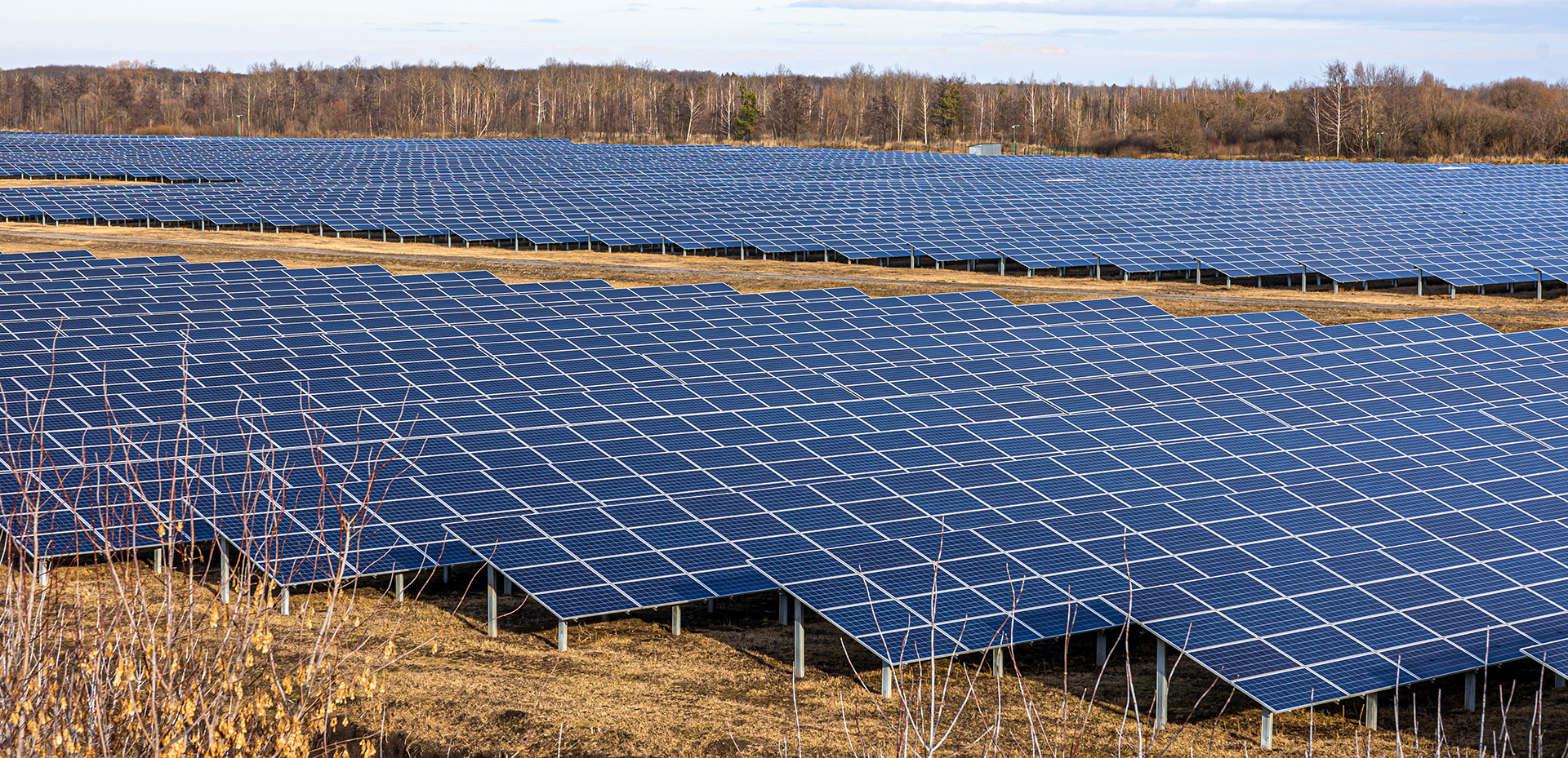 View of the solar power plant on a green field. Electric farm with panels for producing clean ecologic energy.